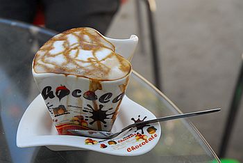 Latte Macciato aus einer Tasse in Herzform.